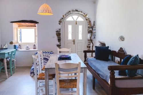 Blue & White: An Absolute Aegean dream house في Galini: غرفة معيشة مع طاولة وكراسي وغرفة طعام