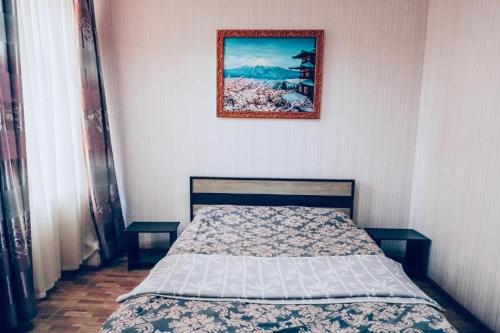 Konotop的住宿－ShangHai Hotel，卧室内的一张床铺,墙上挂着一幅画