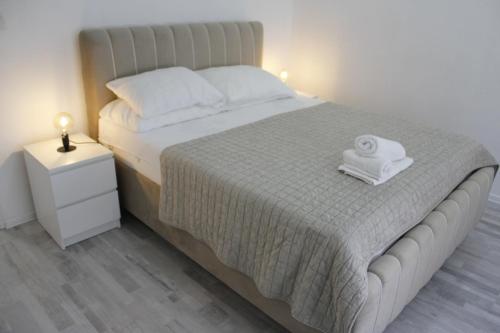 a bedroom with a large bed with two towels on it at Apartments Luke in Dubrave Gornje