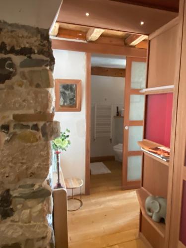 - un salon avec un mur en pierre et une télévision dans l'établissement charmant appartement Annecy, à Annecy