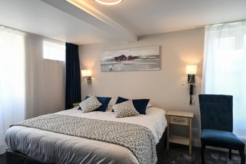 a bedroom with a bed and a blue chair at Belle Normandy in Bayeux