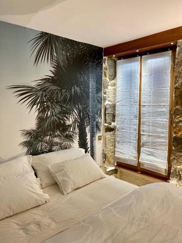 - une chambre avec un lit et une fresque murale de palmiers dans l'établissement charmant appartement Annecy, à Annecy