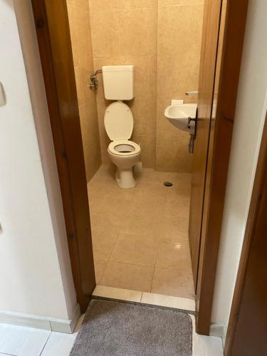 a bathroom with a toilet and a sink at Family Hotel "May" in Petrich