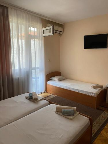 a hotel room with two beds and a television at Family Hotel "May" in Petrich