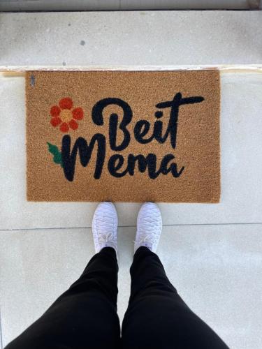 a person with their feet on a sign with the word belt meme at Beit Mema in Aḑ Ḑahr
