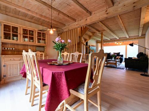 a dining room table with a vase of flowers on it at Chalet La Paisible by Interhome in Ovronnaz