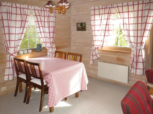 jadalnia ze stołem i krzesłami oraz 2 oknami w obiekcie Holiday Home Granlien - FJS546 by Interhome w mieście Gjølanger