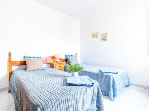 ロザスにあるApartment Els Jardins III by Interhomeのベッドルーム1室(青と白のシーツが備わるベッド2台付)