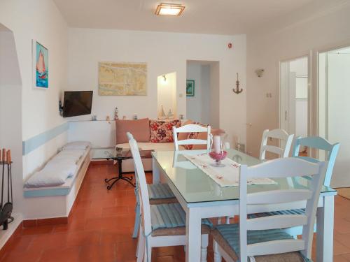 Un comedor con una mesa y sillas y un sofá. en Apartment Marinella-3 by Interhome, en Labin