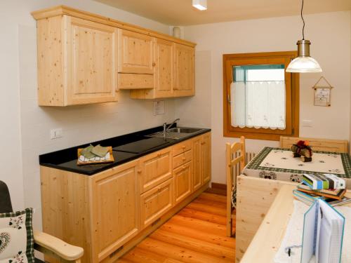 una cocina con armarios de madera y fregadero en Apartment Cjase Fravins-3 by Interhome, en Raveo