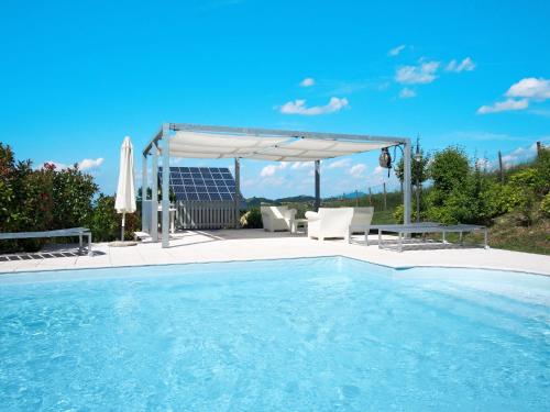 a swimming pool with a canopy and a table and chairs at Holiday Home Villa Sarezzano by Interhome in Sarezzano