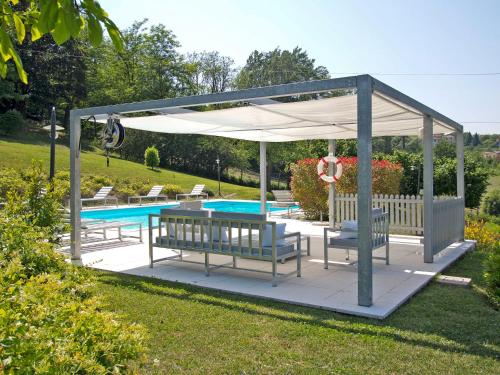 a pavilion with benches and a swimming pool at Holiday Home Villa Sarezzano by Interhome in Sarezzano