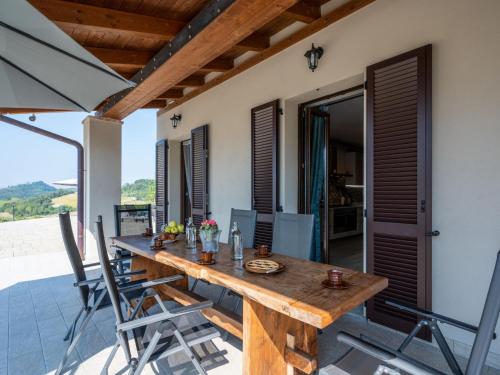 - une table en bois sur la terrasse d'une maison dans l'établissement Holiday Home Casa Chiara - SIC400 by Interhome, à Serralunga di Crea