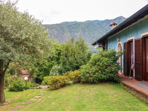 uma casa azul com um quintal com árvores e montanhas em Holiday Home Sulle Colline Casalesi by Interhome em Casale Corte Cerro