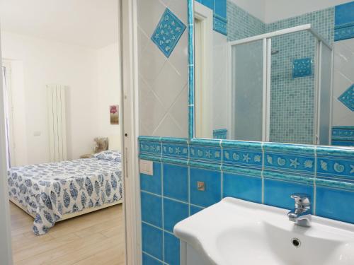 a bathroom with a sink and a mirror and a bed at Holiday Home Red Stones by Interhome in Punta Ala