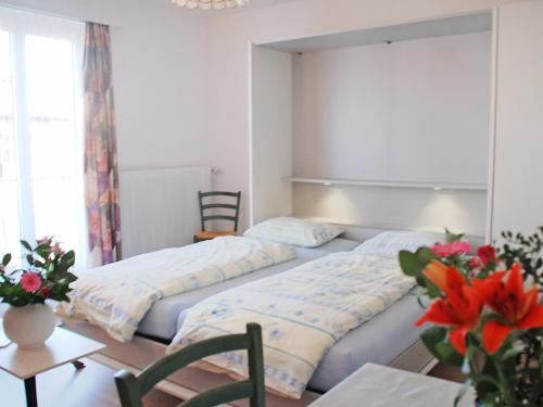 2 Betten in einem Zimmer mit Tisch und Stühlen in der Unterkunft Apartment Corallo - Utoring-7 by Interhome in Ascona