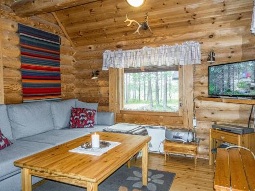 uma sala de estar com um sofá e uma mesa em Holiday Home Fassen maja by Interhome em Ylläsjärvi