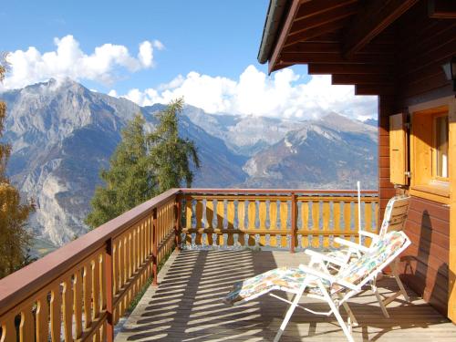 two chairs on a balcony with a view of mountains at Chalet Chalet Boucaro by Interhome in Plan Fey