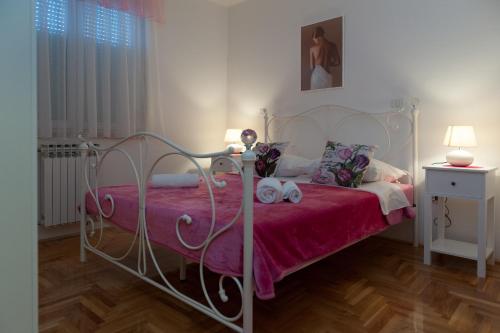 1 dormitorio con cama blanca y manta roja en Apartment Marija, en Zadar