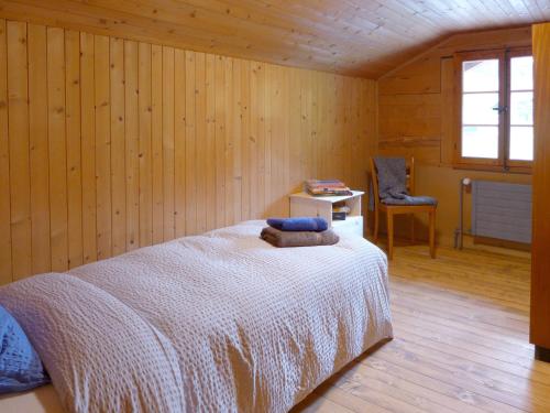 a bedroom with a bed in a wooden room at Apartment Chalet Alte Post by Interhome in Schwenden