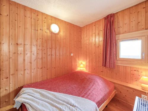 a bedroom with wooden walls and a red bed in it at Apartment Home Club-7 by Interhome in Tignes