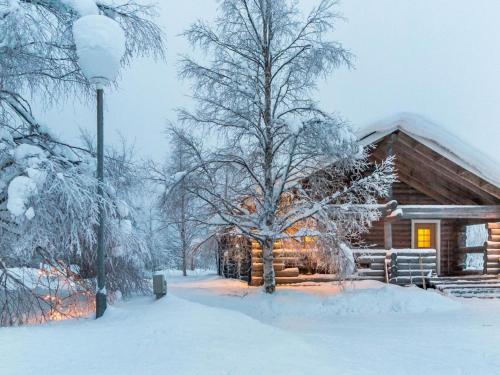 une cabane en rondins dans la neige avec un arbre dans l'établissement Holiday Home Keskiniemi by Interhome, à Nissinaho