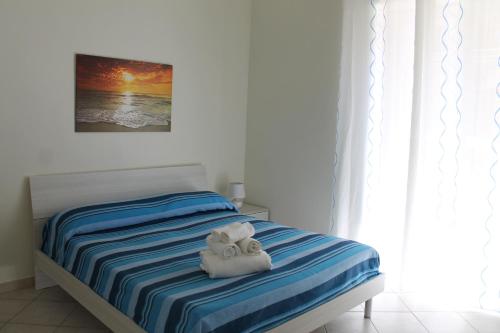 ビシェーリエにあるSea & Sun - Guest Houseのベッドとタオル2枚のある寝室