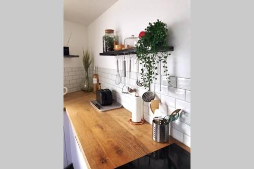 Il comprend une cuisine avec des murs blancs et du parquet. dans l'établissement Maison proche centre ville, à La Rochelle