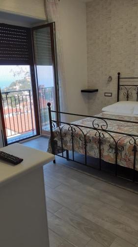 a bedroom with a bed and a balcony at La casetta del borgo in Agerola