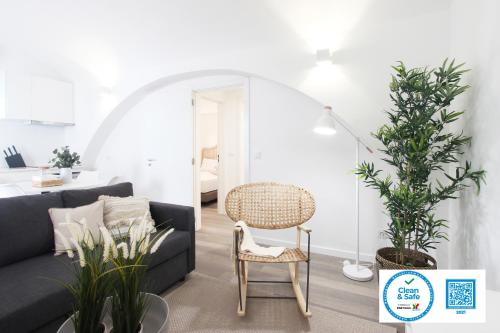 a living room with a black couch and a chair at Lavradores Boutique Guesthouse in Évora