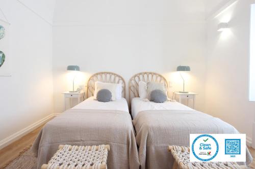 two beds sitting next to each other in a bedroom at Lavradores Boutique Guesthouse in Évora