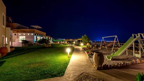 a park at night with a slide and a playground at Alkionis Beach Hotel Apartments in Sfakaki