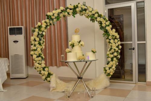 a wedding arch with a wedding cake on a table at Chamba Valley Exotic Hotel in Lusaka