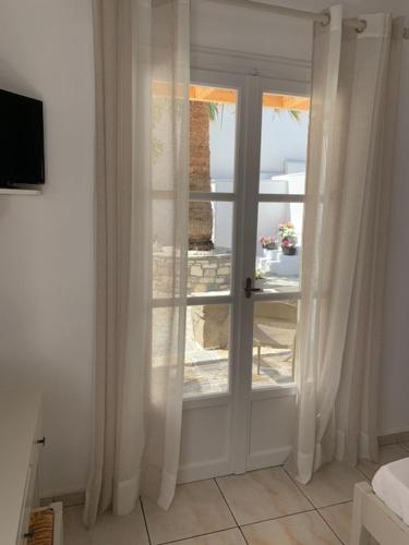 a white door with a window in a room at Sea & Sun Paros in Naousa