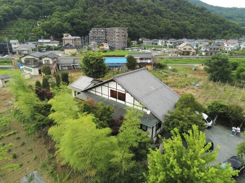 an aerial view of a village with a house and trees at フクロウの御宿 春日居館 in Isawa