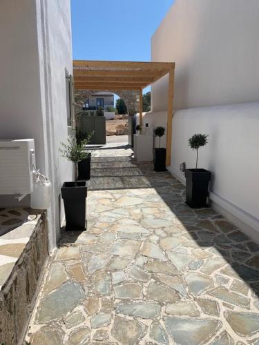 a walkway with potted plants on the side of a building at Sea & Sun Paros in Naousa