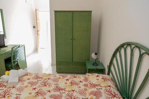 a bedroom with a bed and a green cabinet at Il Complesso Saraceno in Torre delle Stelle