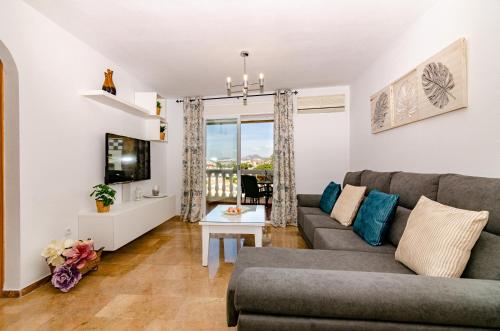 a living room with a couch and a table at WintowinRentals Pool, Sunny side & Free Parking. in Torre de Benagalbón