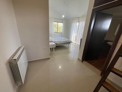 a small room with a bed and a window at Beit Mema in Aḑ Ḑahr