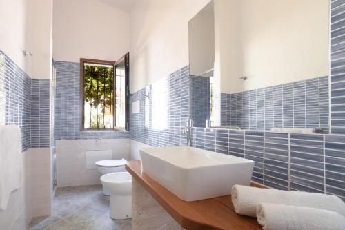 a bathroom with a white sink and a toilet at Orosei Summer Holidays - Cala del Turco green house in Orosei