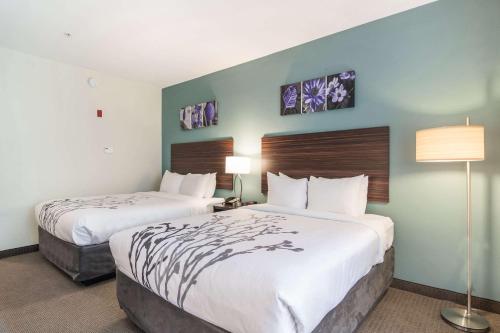 a hotel room with two beds and two lamps at Sleep Inn & Suites At Kennesaw State University in Kennesaw