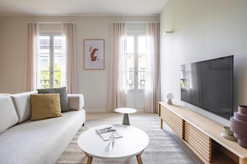 a living room with a large flat screen tv at Aspasios Garden Apartments in Barcelona