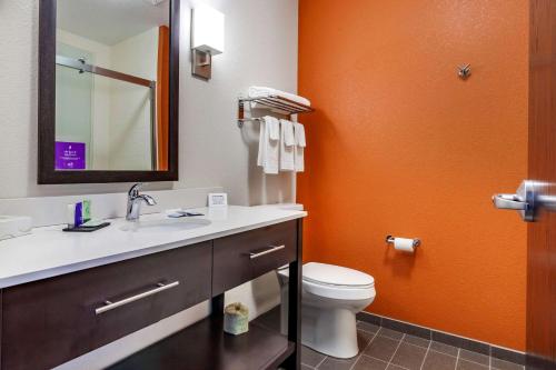 an orange bathroom with a toilet and a sink at Sleep Inn & Suites Lancaster-Platteville in Lancaster