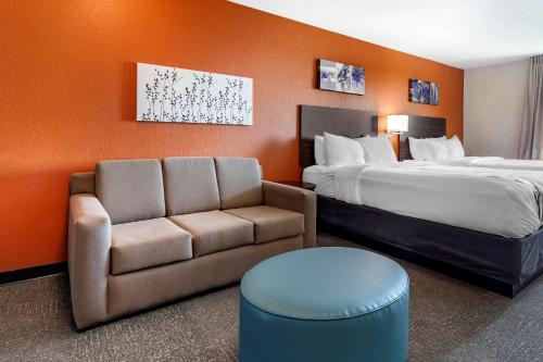 a hotel room with a bed and a couch at Sleep Inn & Suites Lancaster-Platteville in Lancaster