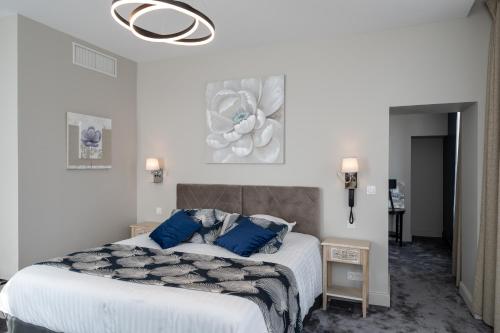 a bedroom with a large bed with blue pillows at Belle Normandy in Bayeux