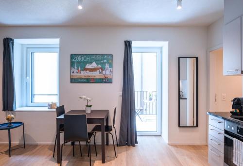 a kitchen and dining room with a table and chairs at HITrental Central Station Apartment in Zürich