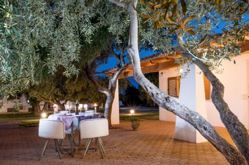 a table and chairs under trees at night at Orosei Summer Holidays - Cala del Turco green house in Orosei