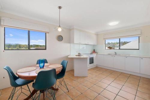 a kitchen with a table and chairs in a room at Laudable Lizzie in Sawtell