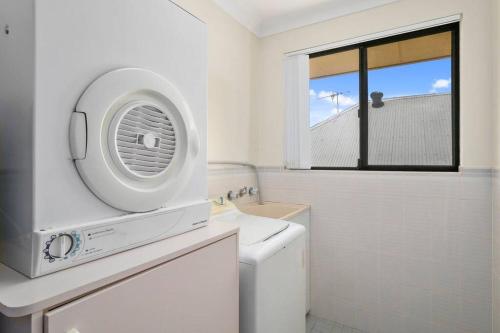 un bagno bianco con un lavandino e una finestra di Laudable Lizzie a Sawtell
