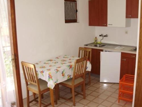 Il comprend une cuisine équipée d'une table, de 2 chaises, d'une table et d'un réfrigérateur. dans l'établissement Apartment in Stari Grad Hvar with balcony, air conditioning, WiFi, dishwasher 5028-2, à Stari Grad